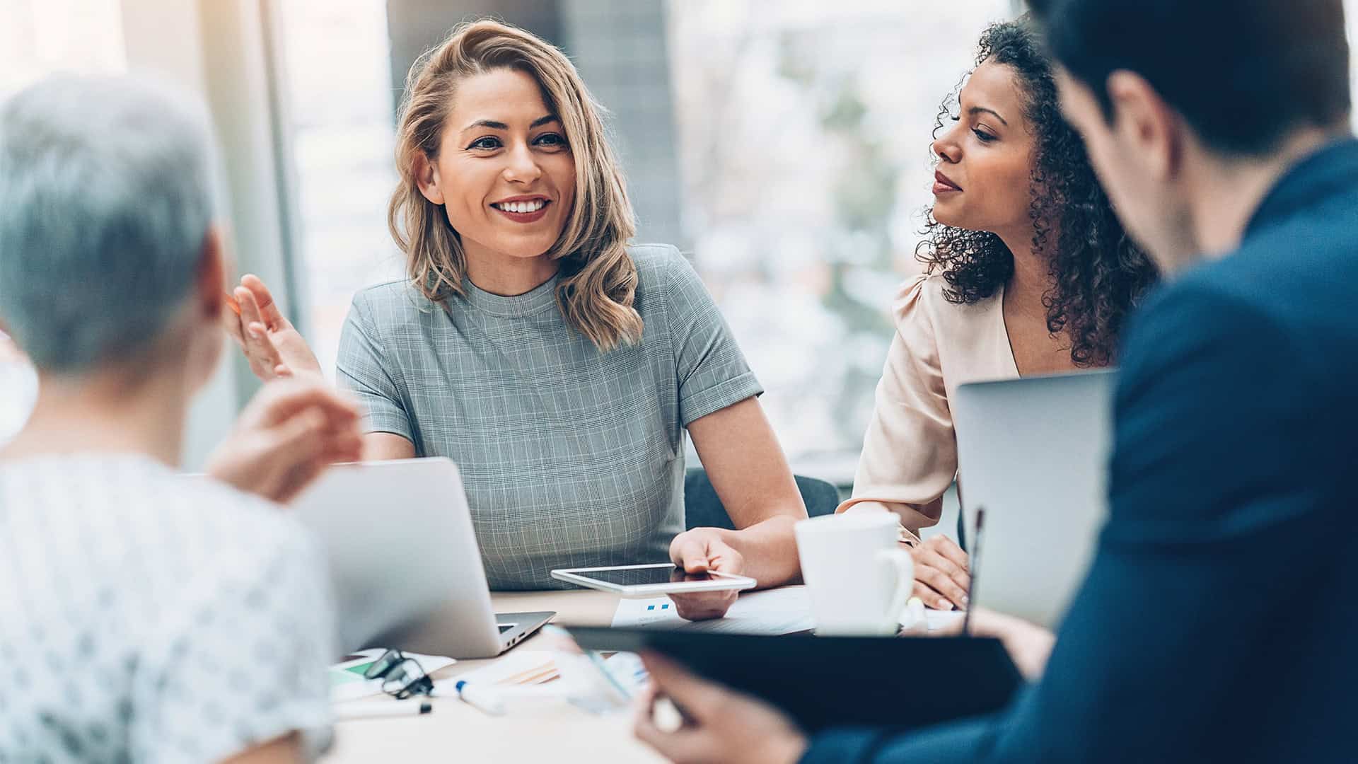 Drei Frauen und ein Mann im Gespräch bei Meisterplan.