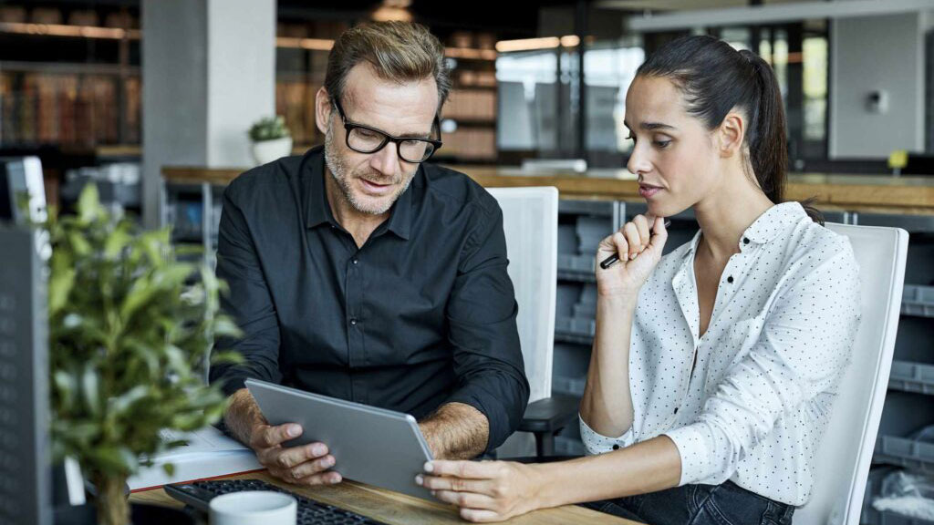 coworkers looking at tablet together in the office